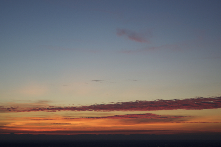 Ein Sonnenuntergang, der die Wolkenunterseite rot färbt